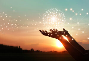 A person holds a glowing orb with a sunset in the background, symbolizing networking technology.