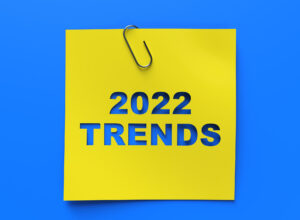 A yellow post-it note that says "2022 TRENDS" against a blue background.