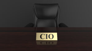 Head-on view of a dark desk and office chair with a gold nameplate that reads "CIO."