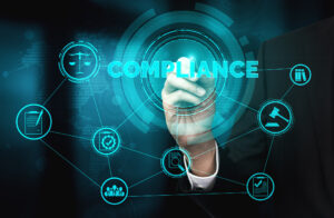A hand points to the word "compliance" surrounded by icons such as a scale, clipboard with a check mark, and other symbols related to compliance.