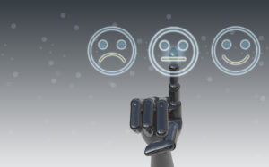 A silver robot hand points to a neutral face in between a frowny face on one side and a smiley face on the other.