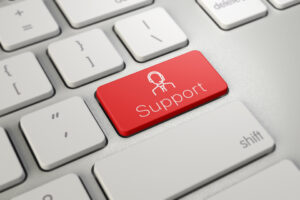 Close up of a keyboard with a red button that says "Support" along with an icon of a person wearing a headset.