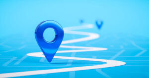 An image of a blue location marker at the beginning of a winding white road against a blue background.