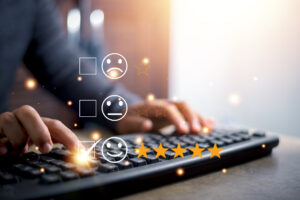Close up of person typing on a keyboard with frowny, neutral, and smiley faces next to checkboxes superimposed over the image. The smiley face as five gold stars next to it.