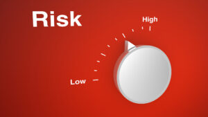 A dial against a red background labeled "Risk" with a range of low to high. The dial is set midway between the two extremes.