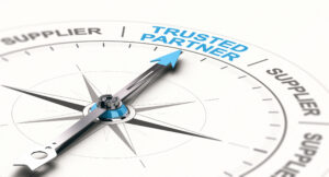 Close up of a compass divided into sections that mostly say "Supplier." The arrow points at the one section that reads "Trusted Partner." 